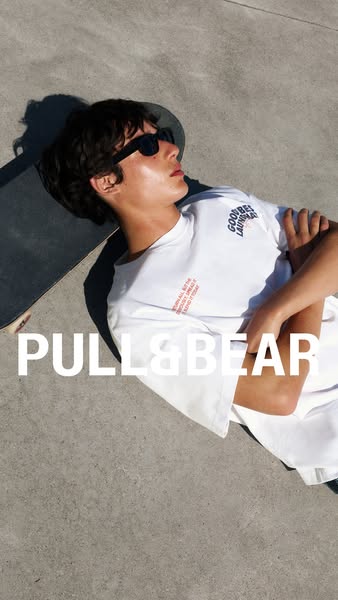 This ad showcases a white t-shirt from Pull&Bear being worn by a young man while he is hanging out with his skateboa