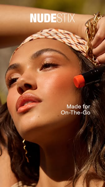This ad features a close-up shot of a woman applying Nudestix makeup. The ad highlights the product's portability an
