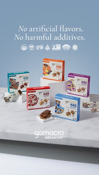 The ad showcases GoMacro Kids macrobars in various flavors, highlighting their absence of artificial flavors and harmful