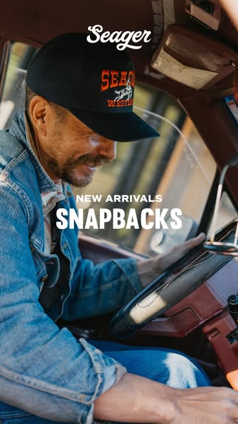 This image ad promotes Seager snapback hats. The photo features a man wearing a Seager hat while driving a car. The ad h