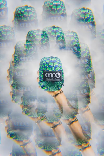 This ad features a person holding a tightly packed DoubleNest hammock, from ENO. The image is heavily distorted and slig