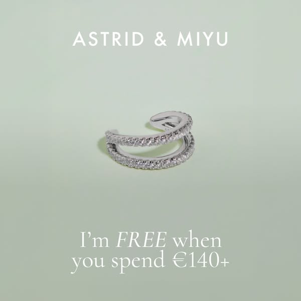This ad for Astrid & Miyu features a silver-colored ear cuff against a solid light-green background. The text offers