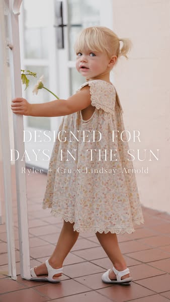 A lifestyle ad showcasing a young child in a floral dress. The dress is part of a designer collaboration with Rylee + Cr