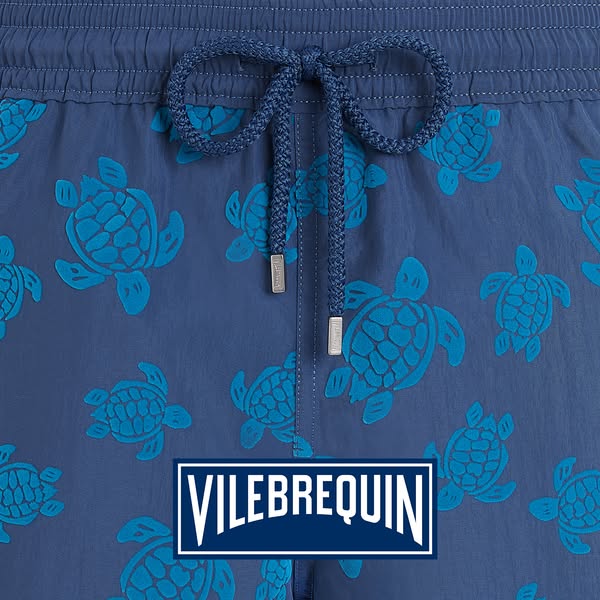 This ad features an up-close image of Vilebrequin swim trunks with a blue sea turtle print. The shot focuses on the wais