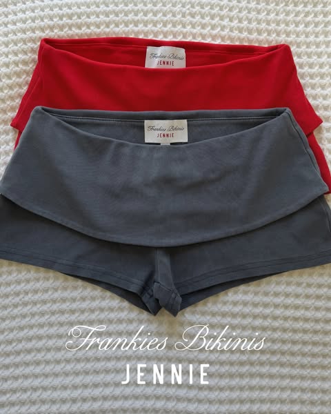 This ad features two pairs of Frankie's Bikinis brand shorts. The shorts are styled as a product flatlay, set agains