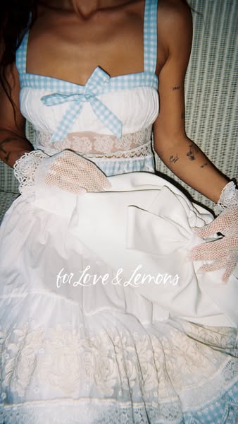 This ad features a woman modeling a blue and white 'for Love & Lemons' dress. The shot highlights the dress&