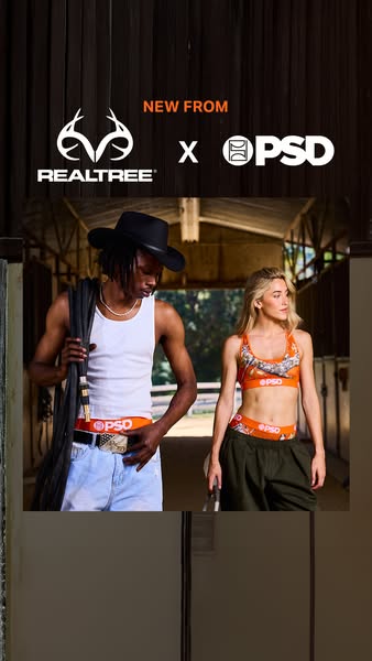 This image ad showcases a collaboration between Realtree and PSD. Two models are posing inside of a horse stable, wearin