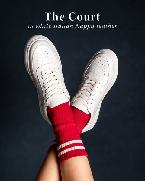 This image ad showcases a pair of white leather sneakers. The headline presents the name and key material of the shoe. T