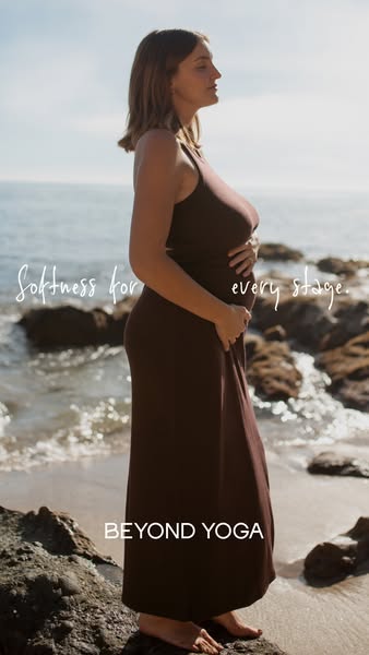 This ad showcases a pregnant woman standing on a beach, wearing a brown dress from Beyond Yoga. The ad copy highlights t