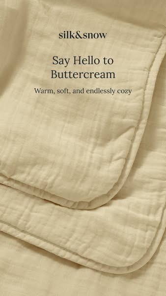 A close-up image ad featuring a Silk & Snow throw blanket in the Buttercream color. The focus is on the soft and coz