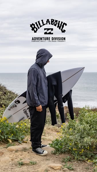 This image ad features a person standing on a bluff overlooking the ocean. They are wearing Billabong clothing while car
