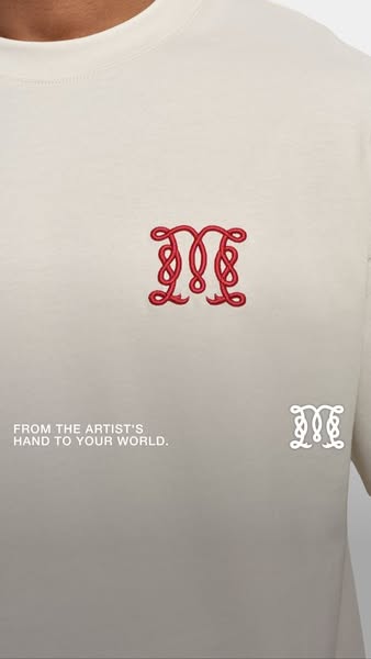 The image ad shows a close-up of a cream-colored t-shirt with a red, embroidered design on the chest. The embroidered de