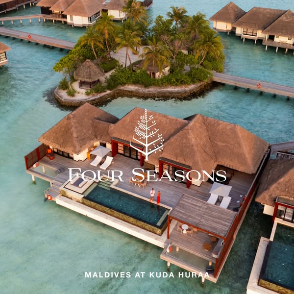 This image ad showcases an aerial view of the Four Seasons Maldives at Kuda Huraa, emphasizing the luxurious overwater b