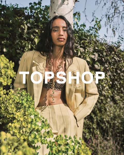 This Topshop ad features a woman in an outdoor setting wearing a blazer and pants. The ad aims to showcase the brand'