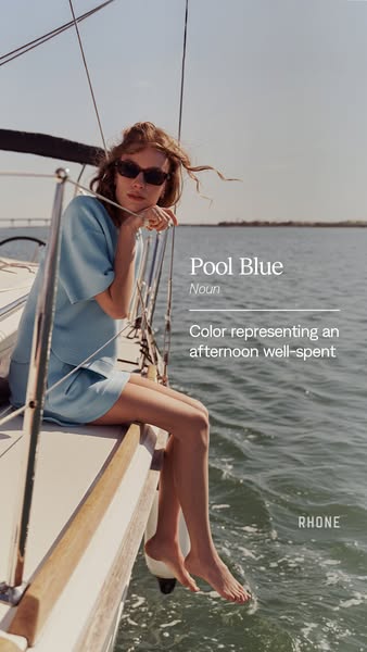 The image ad for Rhone features a woman sitting on a sailboat. She is wearing a matching pool blue Rhone short sleeve se
