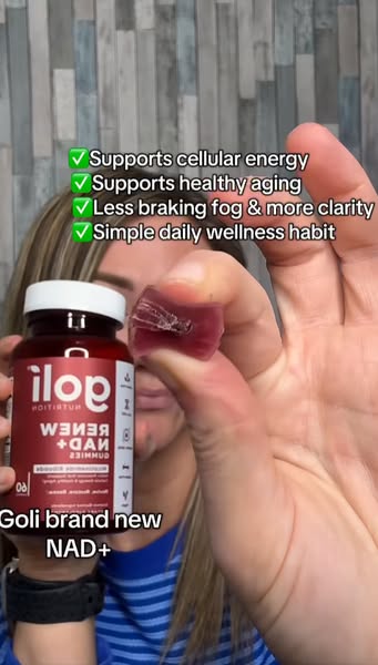 This ad features a woman holding up a bottle of Goli brand new NAD+ gummies and one of the gummies to highlight their be