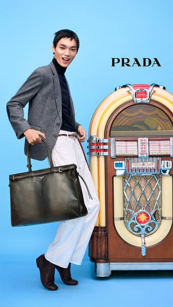 This ad features a man in a suit carrying a Prada bag next to a jukebox.
