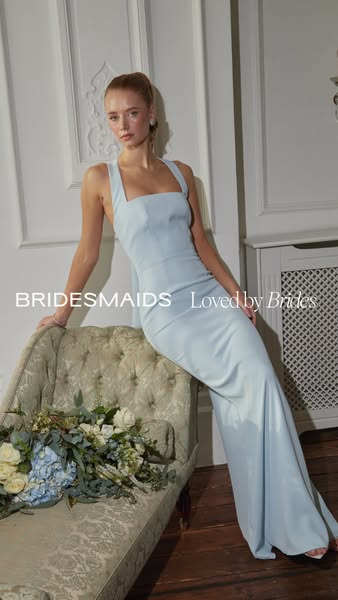 This image ad showcases a woman in a light blue bridesmaid dress, leaning against a chaise lounge with a bouquet of flow