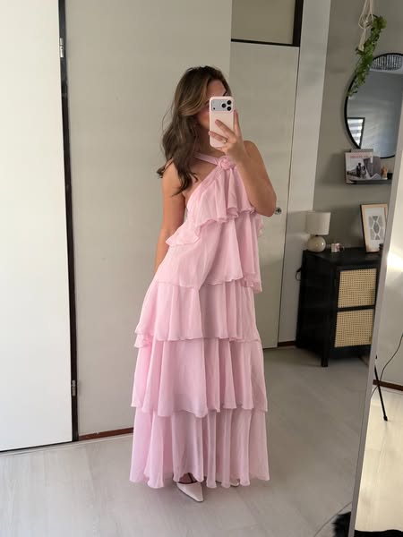 A woman models a pink ruffle maxi dress.
