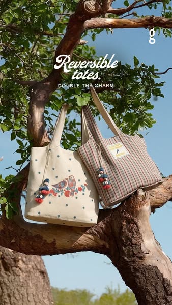 An image ad promoting reversible totes. The visual shows two bags hanging from a tree branch, highlighting their design 