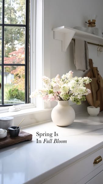 This image ad features a vase of flowers on a kitchen counter next to a window, accompanied by the text: "Spring Is