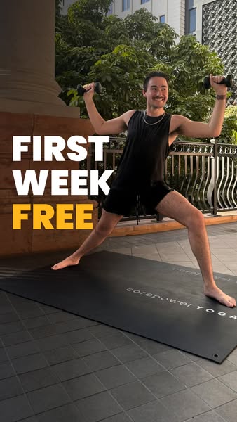 A man stands on a Corepower Yoga mat while holding small weights to promote the offer of a free first week.
