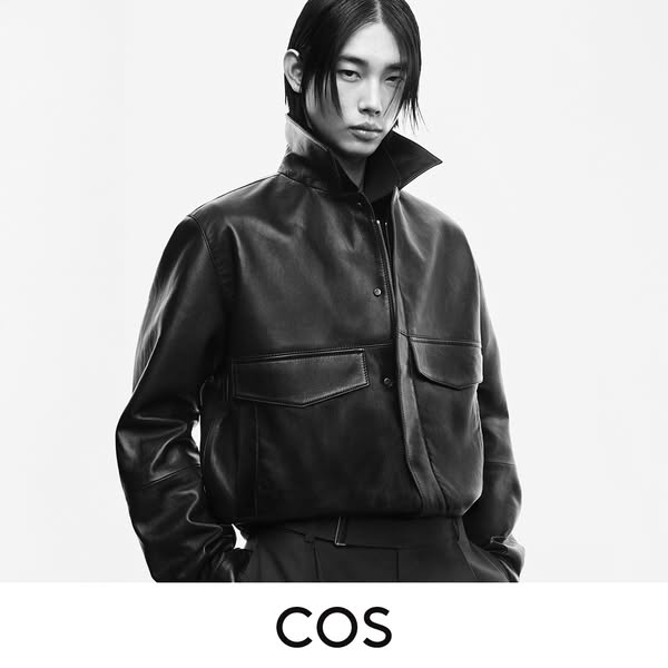 An image ad featuring a person wearing a black leather jacket from COS. The ad is in black and white and features the br