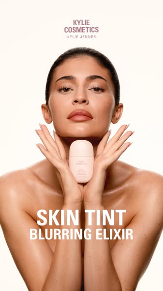 This ad features Kylie Jenner holding a bottle of Skin Tint Blurring Elixir. The image showcases the product and the mod