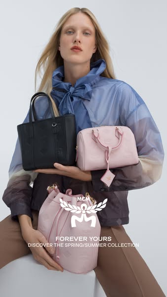 This ad features a fair-skinned woman holding up three MCM handbags: a black tote, a pink shoulder bag, and a pink bucke
