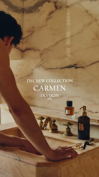 This ad for the Carmen collection by Trudon features an aesthetic shot of a marble bathroom and a person at the sink nex