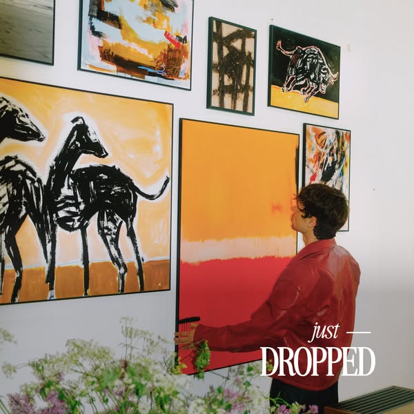 An image promoting a new art drop, featuring a man hanging a painting. The image aims to capture the essence of the bran