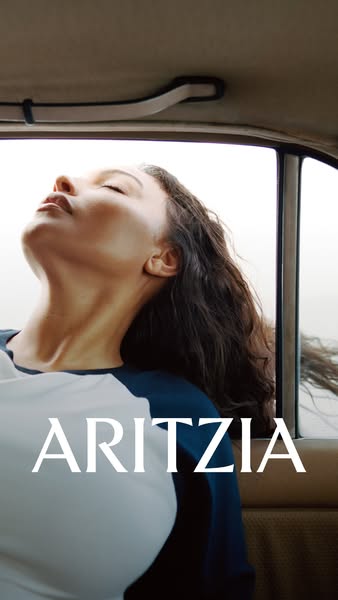 This Aritzia ad features a young woman with dark hair and a white and blue baseball tee in what appears to be the back s