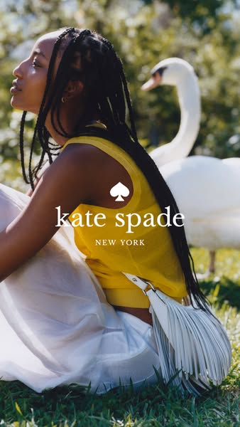 This ad for Kate Spade features a woman with long braids in a yellow tank top and white skirt sitting in a grassy field 