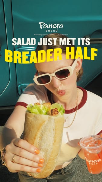 This Panera Bread ad features a woman outside in natural lighting holding a salad sandwich while also holding a drink. T