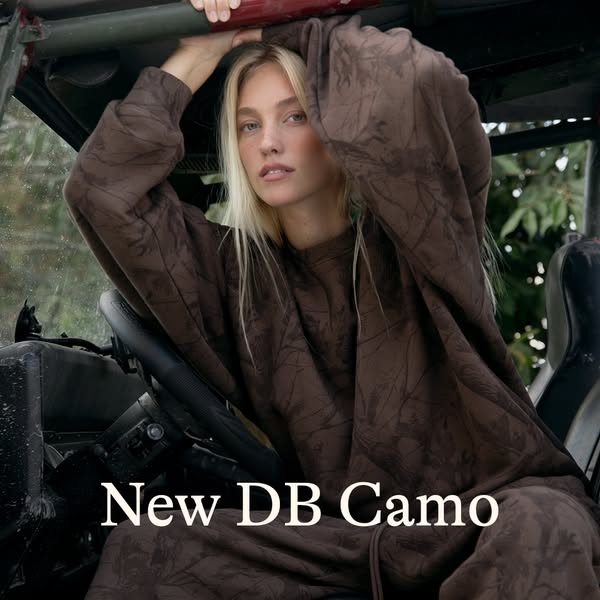 This is an image ad promoting the new DB Camo clothing line from a brand. It features a female model wearing a patterned