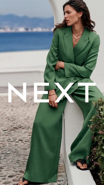 This ad features a woman wearing an emerald green suit. The ad promotes the brand 'NEXT'.