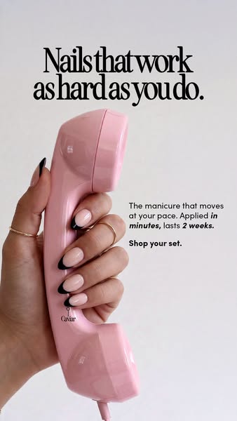 This image ad features a woman's hand holding a pink telephone to her ear. Her nails are painted in a french manicur