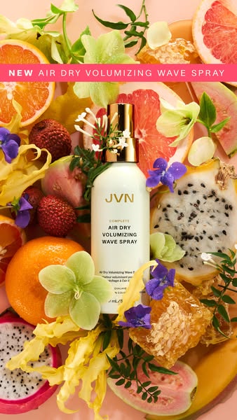 This ad features the JVN Complete Air Dry Volumizing Wave Spray. The spray is shown in a still life, surrounded by vario