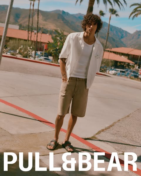 This ad showcases a man standing outside near palm trees in a white shirt and tan shorts. It is advertising the brand Pu