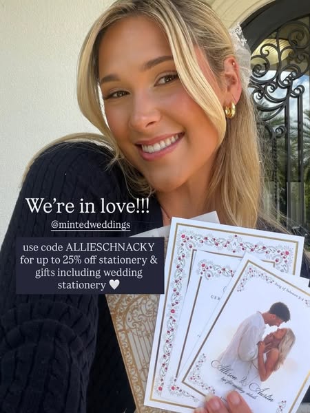 An influencer is promoting Minted wedding stationery in a selfie-style image. She holds a selection of invitation design