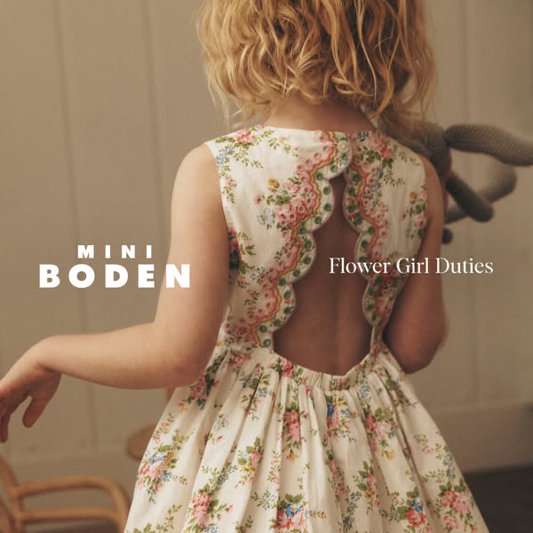 This ad features a young girl wearing a floral dress, promoting Mini Boden's children's clothing line with an em