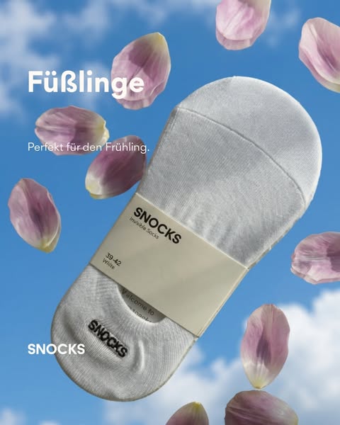 The ad showcases the Snocks brand of invisible socks. The product is presented with pink petals floating around it again