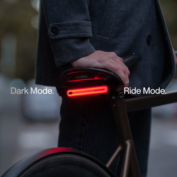This image ad demonstrates the use of the Brooks rear bicycle light by showing a close up of the bike with the rear ligh