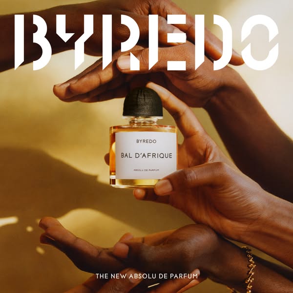 This image ad showcases the Byredo Bal D'Afrique Absolu de Parfum. The ad features the product being held by hands a