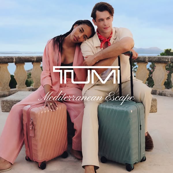 This ad features a couple sitting on a ledge with their luggage, advertising TUMI's Mediterranean Escape collection.