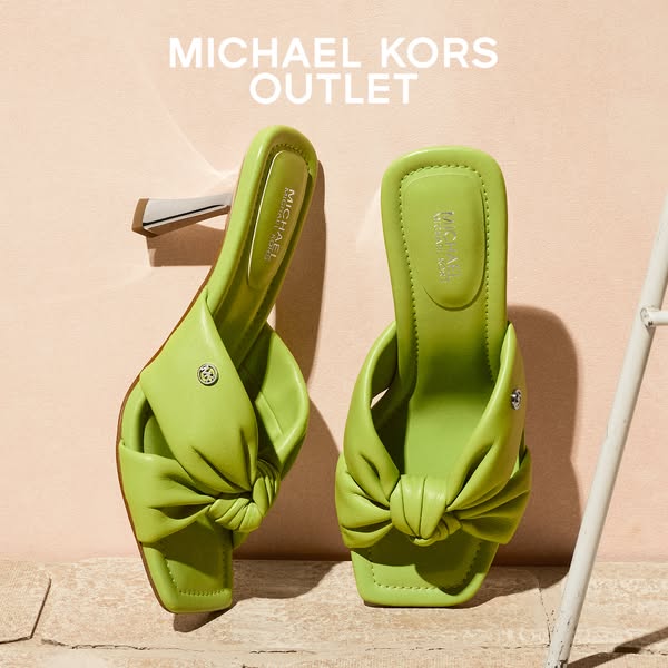 This ad showcases a pair of lime green Michael Kors heels. The shoes are displayed against a peach and stone-textured ba