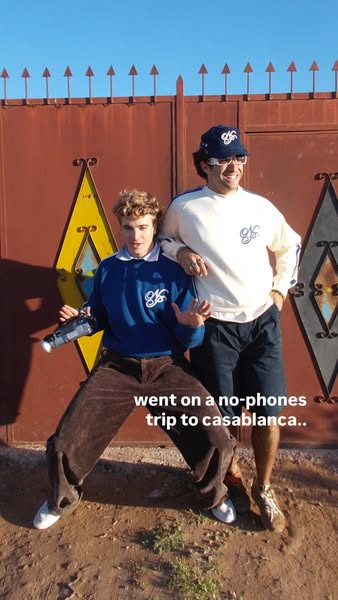 A lifestyle photo depicts two men wearing clothing from the brand in front of an ornate gate while on a trip to Casablan