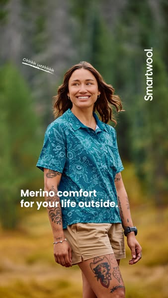 This ad showcases a woman in an outdoor setting wearing apparel made by Smartwool. The focus is on merino wool comfort f