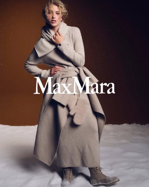 This ad showcases a woman wearing a Max Mara coat, scarf, and mittens in a snowy setting.