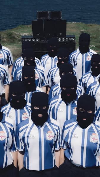 This ad features a group of people wearing matching outfits, masks, and a stack of audio speakers in the background. It 